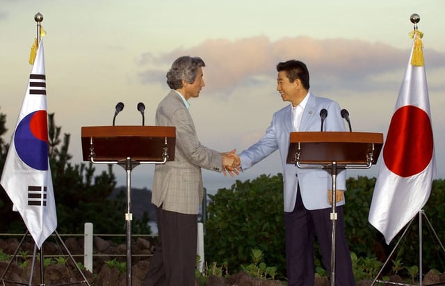 Japanese Prime Minister Junichiro Koizumi (left) shakes hands with South Korean president Roh Moo-hyun in Jeju after a joint press conference in July 2004. Photo: AFP