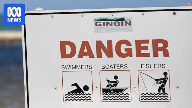 A warning sign in front of a river.