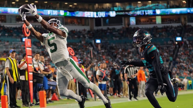 Sep 29, 2025; Miami Gardens, Florida, USA; New York Jets wide receiver Garrett Wilson (5) attempts to make a catch against Miami Dolphins cornerback Artie Burns (23) during the second half at Hard Rock Stadium. Mandatory Credit: Sam Navarro-Imagn Images