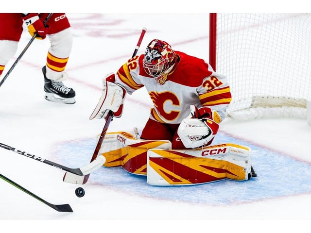 Calgary Flames goaltender Dustin Wolf makes a save during the first period of an NHL hockey game against the Seattle Kraken, Monday, Sept. 29, 2025, in Seattle.