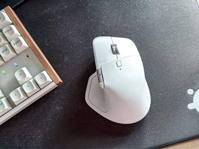 Logitech MX Master 4 mouse on mouse pad next to keyboard