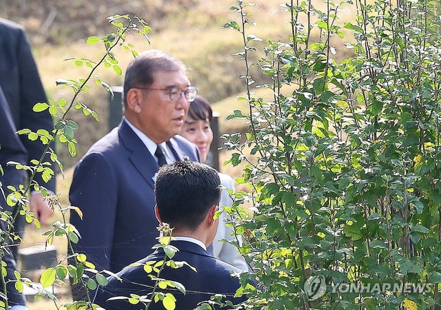 Japanese Prime Minister Shigeru Ishiba visits the grave of South Korean student Lee Soo-hyun at a cemetery in the southeastern port city of Busan on Sept. 30, 2025, to pay tribute to Lee, who was killed attempting to rescue a Japanese man from a subway train track in Tokyo in 2001. (Yonhap)