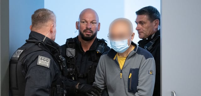 Der Hauptangeklagte Jian G. (2.v.r.) wird vor Prozessbeginn in den Gerichtssaal geführt
