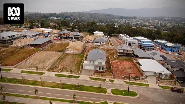 An aerial photo of a new housing estate with empty blocks and several new houses being built.