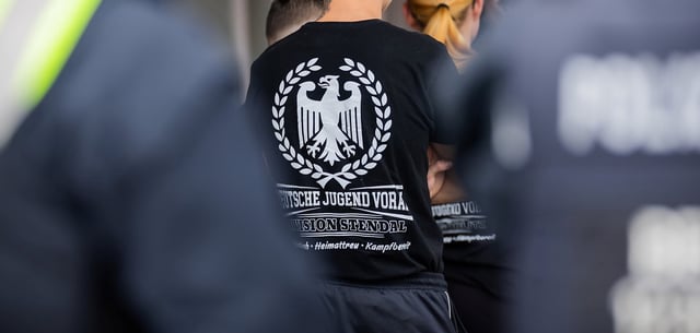 Ein Mann trägt ein T-Shirt mit der Aufschrift „Deutsche Jugend Voran“