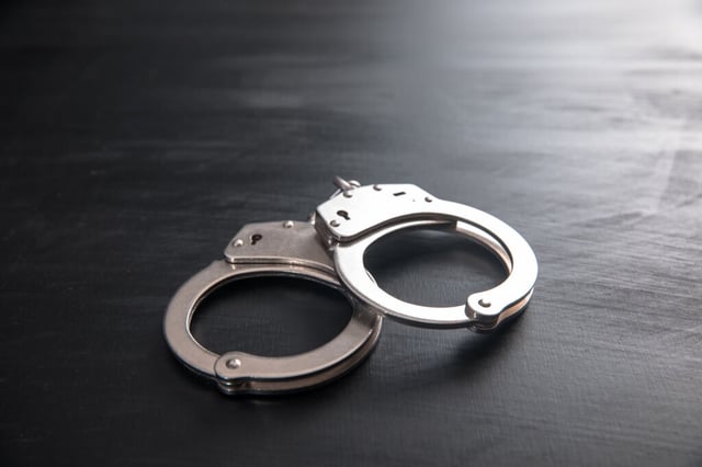 Handcuffs on wooden background