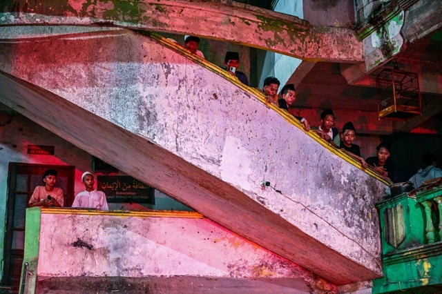 Des étudiants observent les recherches des secours pour trouver des survivants à l'école islamique effondrée de Sidoarjo, en Indonésie, le 29 septembre 2025