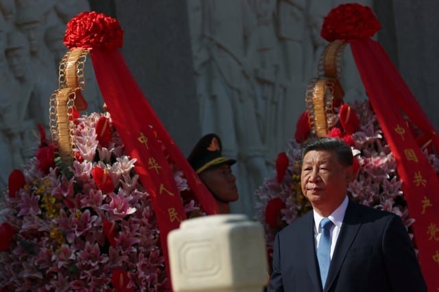 Chinese President Xi Jinping walks past floral baskets at the Monument to the People's Heroes during a ceremony to mark Martyrs' Day, a day ahead of the National Day on Tiananmen Square in Beijing, China September 30, 2025. REUTERS/Florence Lo