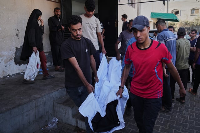 Palestinians carry the body of their relative, killed in an Israeli military strike, at the Al-Aqsa Hospital in Deir al-Balah, central Gaza Strip, Tuesday, Sept. 30, 2025. (AP Photo/Abdel Kareem Hana)