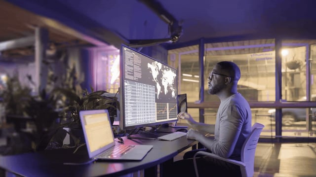 Person sitting at a desk looking at a computer screen.