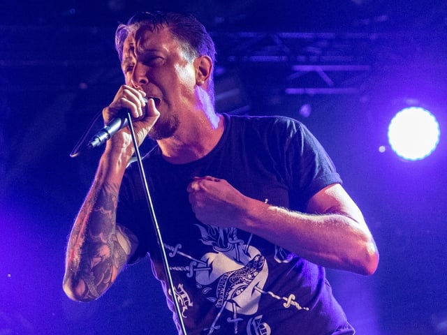 Lou Koller singing with Sick Of It All onstage in 2022