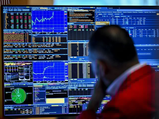 A trader works on the floor of the New York Stock Exchange during morning trading on August 13, 2025 in New York.