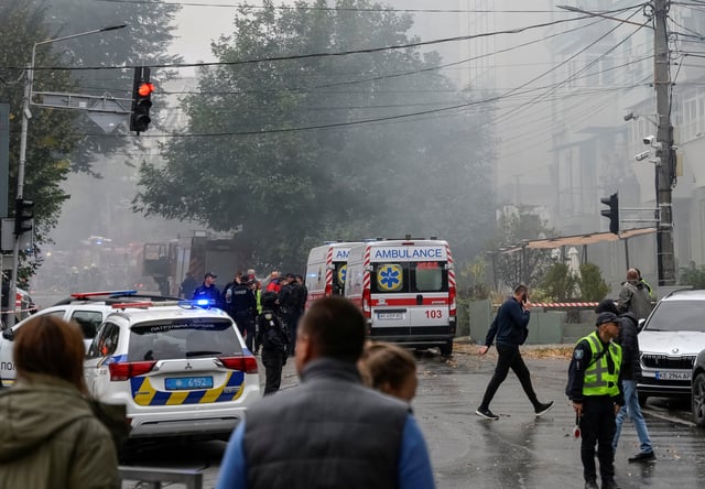 A rescuer and police officers walk at the site of the Russian drone strike, amid Russia's attack on Ukraine, in Dnipro, Ukraine September 30, 2025. REUTERS/Maksym Kishka