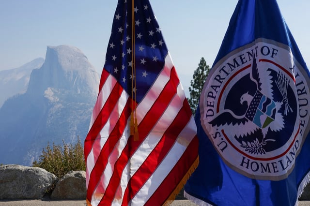 An American flag and a Department of Homeland Security flag stand at a naturalization ceremony at the Glacier Point amphitheater in Yosemite National Park, California, U.S., September 17, 2025.  REUTERS/Tracy Barbutes
