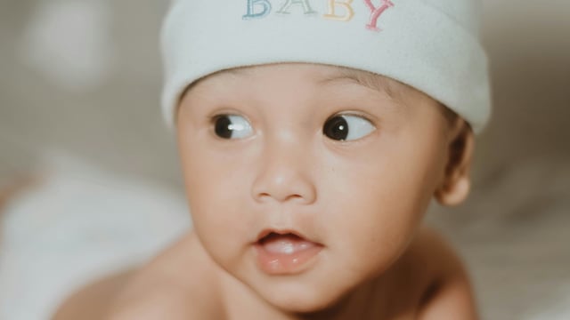 A cute baby looks sideways.