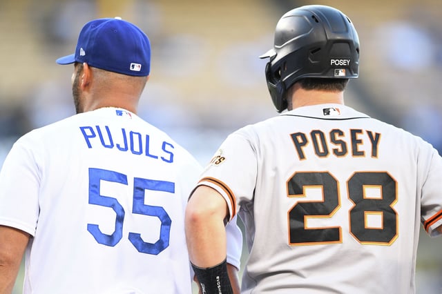 Los Angeles Dodgers first baseman Albert Pujols and San Francisco Giants catcher Buster Posey look on during an MLB game between the San Francisco Giants and the Los Angeles Dodgers on July 20, 2021, at Dodger Stadium in Los Angeles.