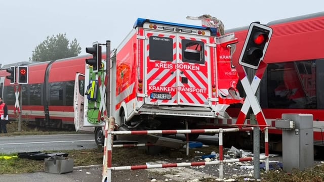 Ein Krankenwagen bleibt mitten auf den Gleisen stehen, dann kommt der Zug.