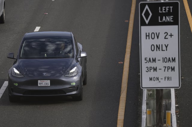 LARKSPUR, CALIFORNIA – SEPTEMBER 30: A Tesla car with California Clean Air Vehicle decals drives in the high occupancy vehicle (HOV) lane on Highway 101 on September 30, 2025 in Larkspur, California. California’s Clean Air Vehicle decal program, which allows solo electric vehicle drivers to use carpool lanes, will expire on October 1 after Congress declined to pass legislation to authorize an extension to keep the program going. Nearly half a million electric vehicle drivers will now be required to meet occupancy requirements in HOV lanes or face a ticket that could be as high as $490. (Photo by Justin Sullivan/Getty Images)