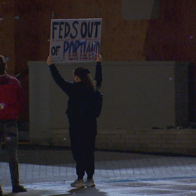 A protester holds up a sign that reads "Feds out of Portland" at the ICE facility in south Portland - KATU photo