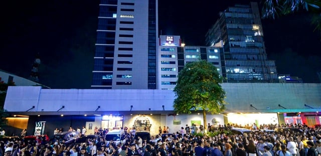 Les employés du centre d'appels surfent sur leurs téléphones portables alors qu'ils se rassemblent devant leur immeuble de bureaux après les secousses du tremblement de terre à Cebu, dans le centre des Philippines, le 30 septembre 2025