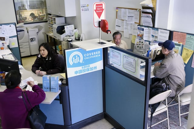 People sign up for health insurance through Covered California at the Asian Health Services offices in Oakland in January 2017. Nearly 1.7 million Californians could soon face steep increases in Covered California premiums if Congress does not extend federal subsidies.
