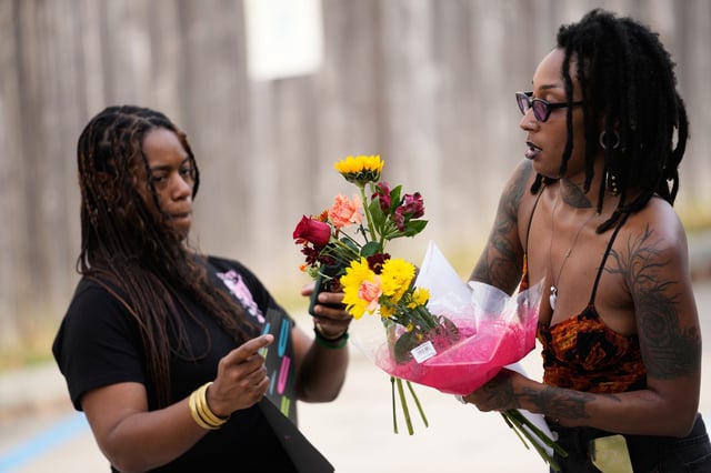 Moonlight Phillips, right, and Victoria Williams, members of the Louisiana Coalition for Reproductive Freedom, arrive at Planned Parenthood on the day they are closing, to deliver cards and flowers to the organization, in New Orleans, Tuesday, Sept. 30, 2025. (AP Photo/Gerald Herbert)