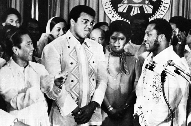 In this Sept. 18, 1975 photo, Philippines President Ferdinand Marcos, left, applauds as challenger Joe Frazier, right, makes some remarks about world champion Muhammad Ali, second from left, during their call on Marcos at the Malacanang Palace in Manila, Philippines. (AP Photo/Jess Tan, File)