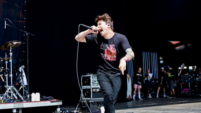 Holding Absence singer performing on stage with mic in hand