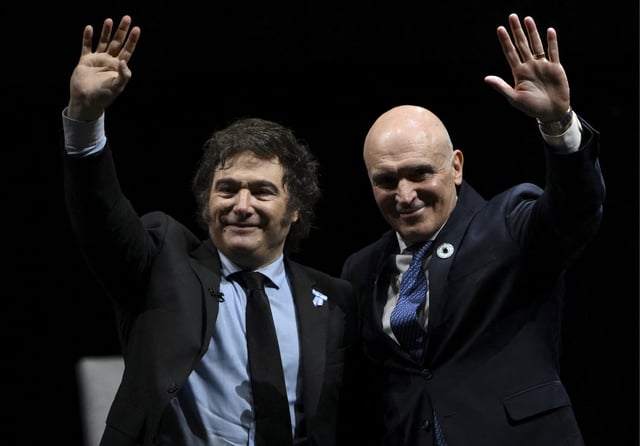 El presidente argentino Javier Milei saluda junto al diputado nacional José Luis Espert durante la presentación de su nuevo libro «Capitalismo, socialismo y la trampa neoclásica» en el estadio Luna Park de Buenos Aires el 22 de mayo de 2024. (Foto: AFP)