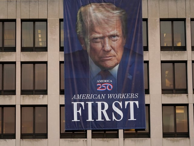 A banner depicting U.S. President Donald Trump hangs on a building on the first day of a partial government shutdown in Washington, D.C., U.S., October 1, 2025. REUTERS/Nathan Howard