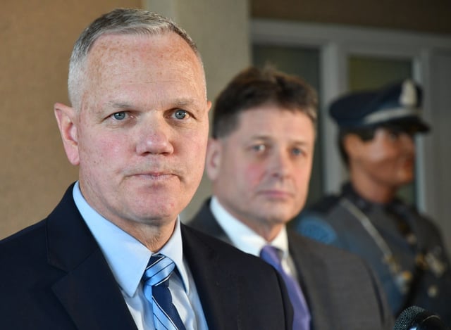 Terrence Reidy  (L) and Scott Warmington (R) listen as State Police Col. Christopher Mason addresses the media Jan. 31, 2020 at State Police Headquarters in FRAMINGHAM, Massachusetts.