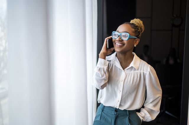 Person wearing glasses and talking on the phone.