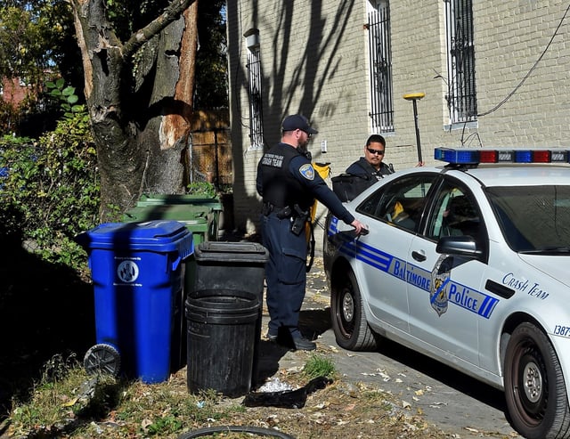 Baltimore City police crash team investigators work in an alley on the 1800 block of Baker Street, where a DPW worker was killed yesterday in an accident.  (Baltimore Sun Staff)