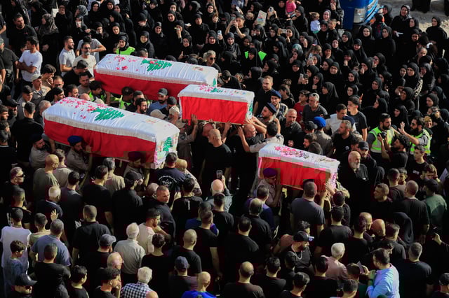 Mourners carry the coffins of four family members killed Sunday in an Israeli drone strike that hit their car, during a funeral procession in Bint Jbeil, southern Lebanon, Tuesday, Sept. 23, 2025. (AP Photo/Mohammed Zaatari)
