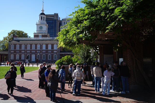 Tourist crowd around a window to view the Liberty Bell with Independence Hall in the background in Philadelphia, Wednesday, Oct. 1, 2025. (AP Photo/Matt Rourke)