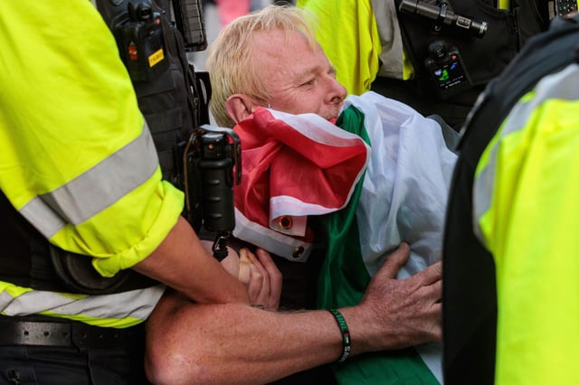 London, UK. 6th September, 2025. Police officers arrest a protester draped in a Palestinian flag during a mass civil disobedience event in Parliament Square organised by Defend Our Juries as part of a campaign against the proscription of direct action group Palestine Action. Photo: Mark Kerrison/Alamy