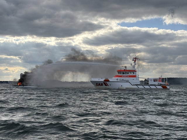 Der Seenotrettungskreuzer „Felix Sand“ der DGzRS bekämpft den Brand auf einer Segelyacht vor Travemünde.