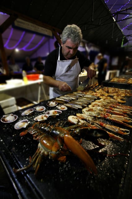 Un cocinero prepara productos frescos en un evento de MarisGalicia.