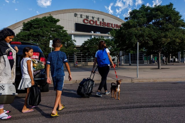 The Mendez family arrives at the Denver Coliseum, driven there by Owen Ceballos, a fellow Venezuelan, on July 14, 2023, in Denver. Ceballos said he came to Denver eight months earlier and earned money by shuttling migrants from the bus station to the temporary shelter in the coliseum. (Armando L. Sanchez / Chicago Tribune)