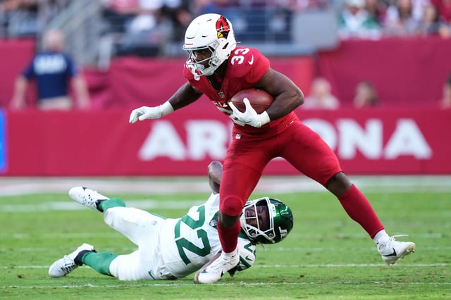 Nov 10, 2024; Glendale, Arizona, USA; Arizona Cardinals running back Trey Benson (33) runs by New York Jets safety Tony Adams (22) during the first half at State Farm Stadium. Mandatory Credit: Joe Camporeale-Imagn Images/ File Photo
