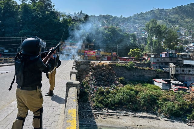 CORRECTS HAME: Police officers fire tear gas shell to disperse members of the Awami Action Committee, a civil rights alliance holding a rally demanding subsidized food, electricity and other services, in Muzaffarabad, the capital of Pakistani controlled Kashmir, Tuesday, Sept. 30, 2025. (AP Photo/M.D. Mughal)