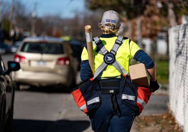 A Canada Post mail carrier delivers packages on their route in Montreal on Nov.13, 2024. THE CANADIAN PRESS/Christinne Muschi