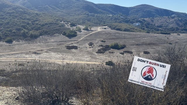 A sign agaisnt the Harmony Grove Village South development project sits on open land. 
