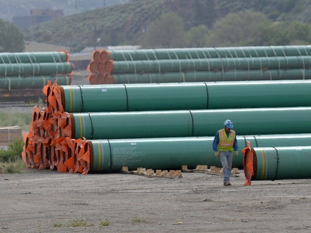 A workman walks past steel pipe to be used in the pipeline construction of the Trans Mountain Expansion Project at a stockpile site in Kamloops. 