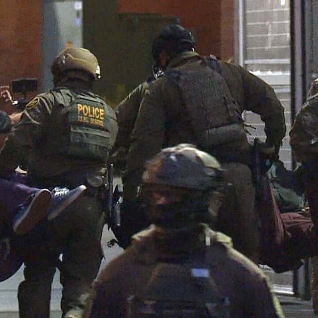 Federal officers carry two protesters into the ICE facility in Portland, Oregon on Tuesday night, Sept. 30, 2025. It was not immediately clear whether the protesters faced any charges. (KATU)