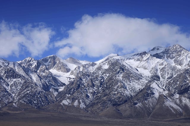 Clouds move over snow-covered mountains in the Eastern Sierra in March 2024. Some glaciers on the range date back to the Ice Age, a new study has found.