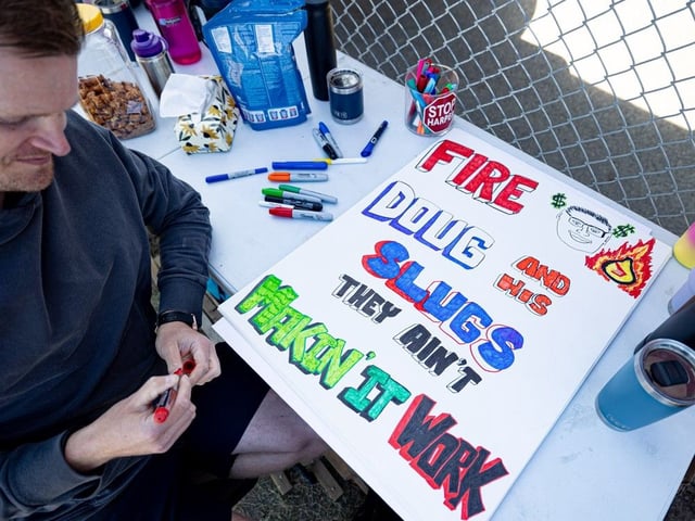  Letter carrier Jameison Leson works on creative posters for picketers outside the main Canada Post office on 51st Street in Saskatoon, Sask. on Wednesday Oct. 1, 2025.