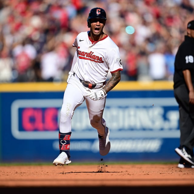 Cleveland Guardians Brayan Rocchio reacts as he rounds the bases after hitting a solo home run in the eighth inning of Game 2 of the American League Wild Card baseball playoff series against the Detroit Tigers in Cleveland, Wednesday, Oct. 1, 2025. Umpire Vic Carapazza looks on at right. (AP Photo/David Dermer)