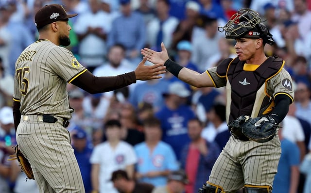 Padres closer Robert Suárez, left, and catcher Freddy Fermin slap hands after the final out against the Cubs in Game 2 of the NL wild-card series Oct. 1, 2025, at Wrigley Field. (Chris Sweda/Chicago Tribune)