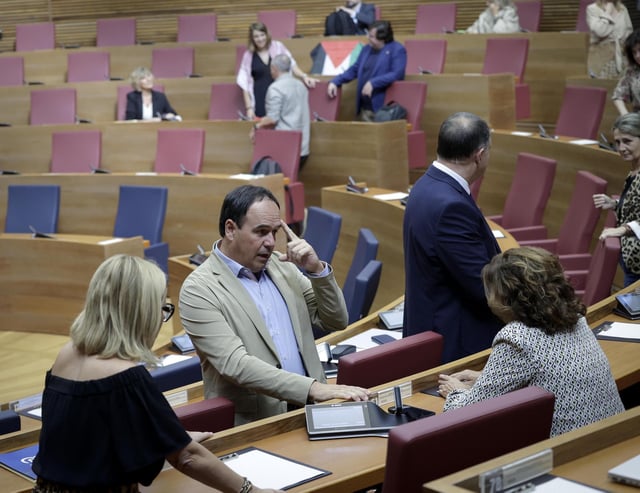 El síndic del PPCV, Juanfran Pérez Llorca, habla con sus compañeros antes de empezar el pleno, este miércoles en las Corts.